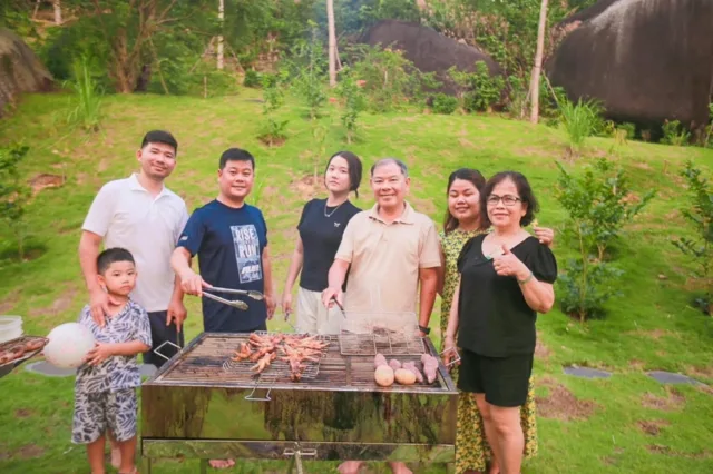 Gia đình nướng BBQ trên bãi cỏ