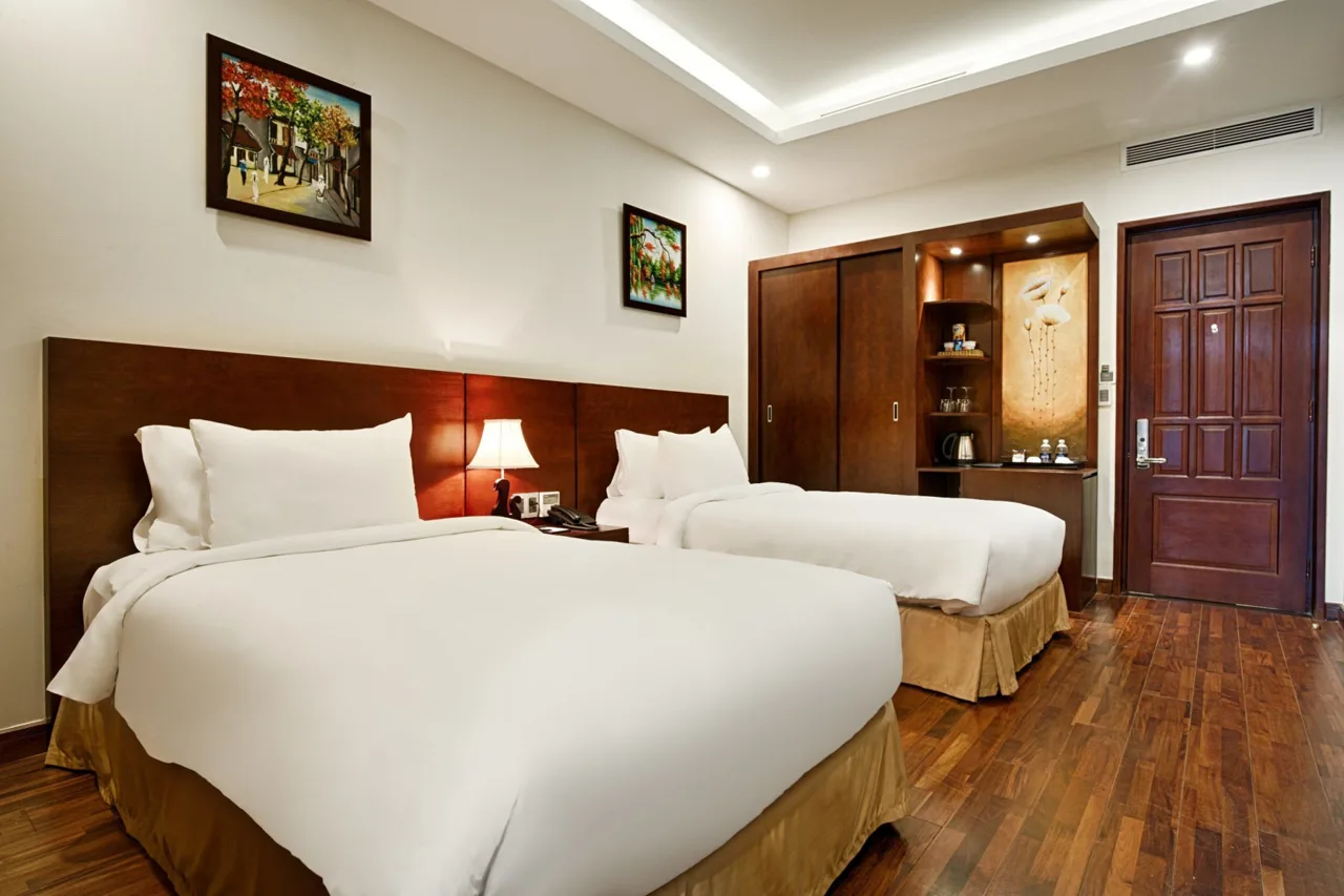 Một giường đôi và một giường đơn trong phòng sàn gỗ