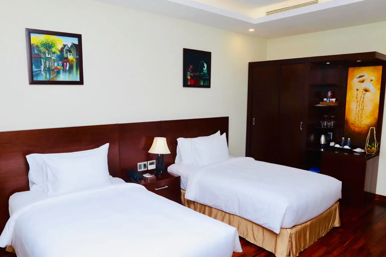 Hai giường đơn kê song song cạnh tủ gỗ