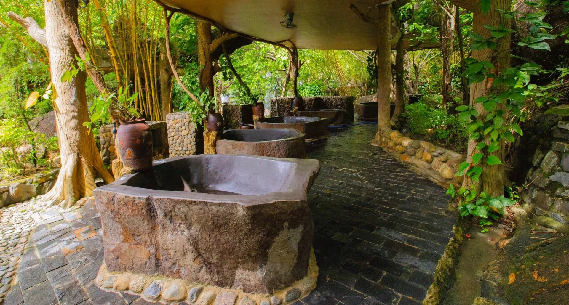 Những bồn bùn khoáng khắc từ đá đặt dưới tán cây