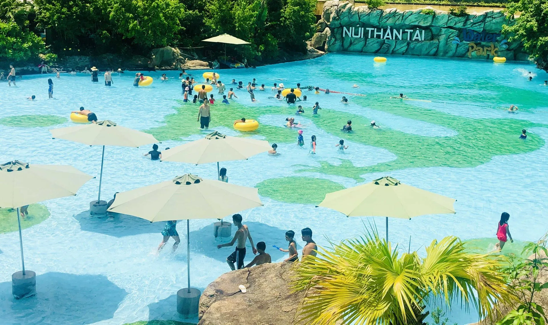Hồ tạo sóng đông vui giữa những tán dù ở công viên nước