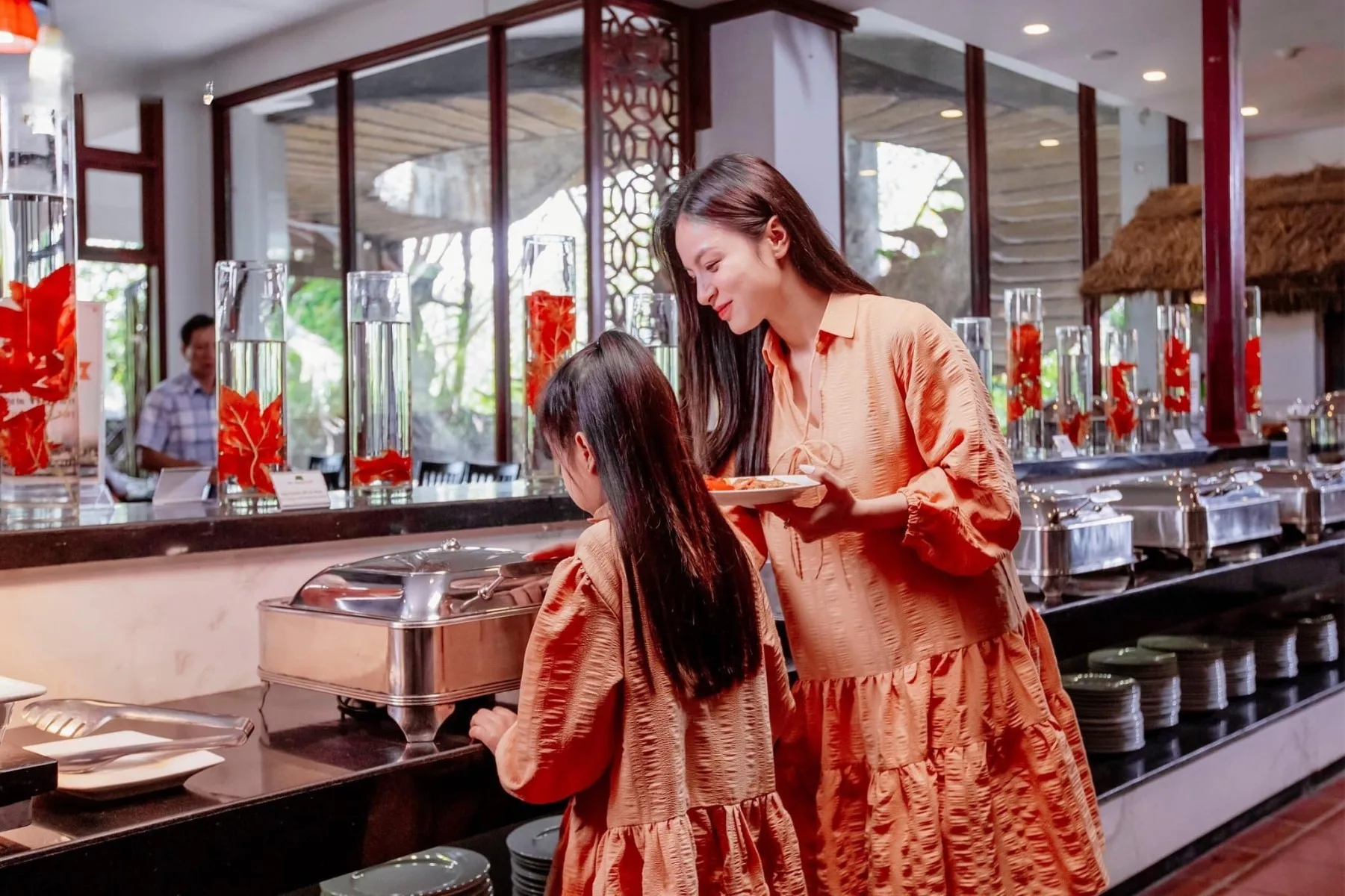 Mẹ và con gái chọn món ở quầy buffet trong khu