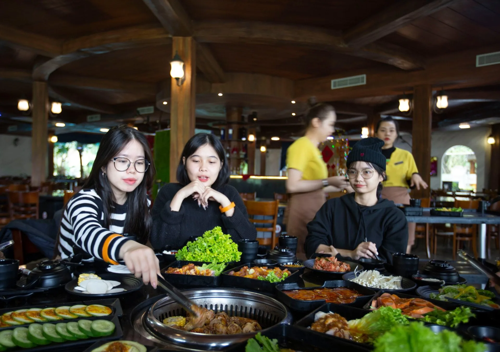 Nhóm bạn nướng BBQ tại bàn trong nhà hàng